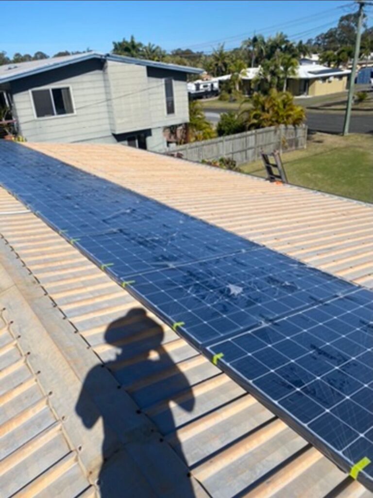 Metal roof with solar panels before cleaning and painting